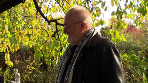 Peter Hakenjos steht ins einem Garten, wo er auch bestatt werden will (Foto: SWR)