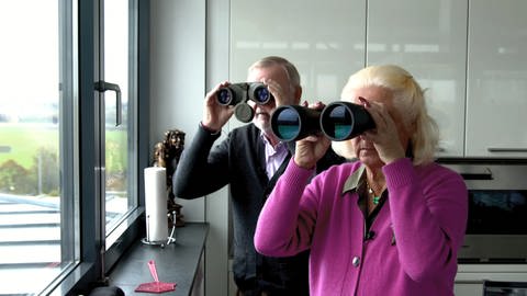 Klaus und Jutta Greinert schauen mit Ferngläsern aus ihrer Penthouse-Wohnung in einem Bunker in Mannheim (Foto: SWR)