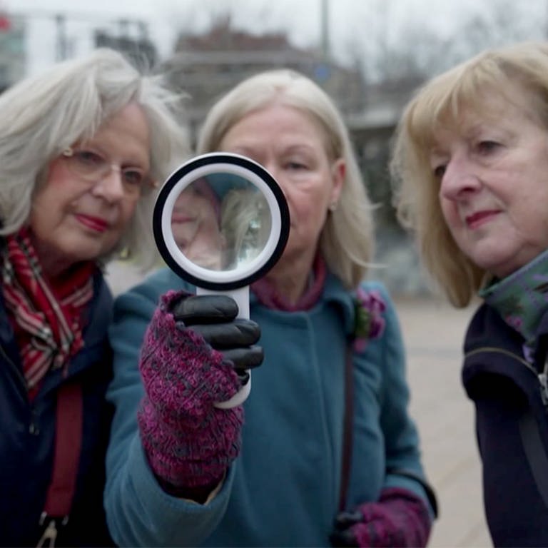 Drei Damen auf der Suche mit einer Lupe (Foto: SWR)