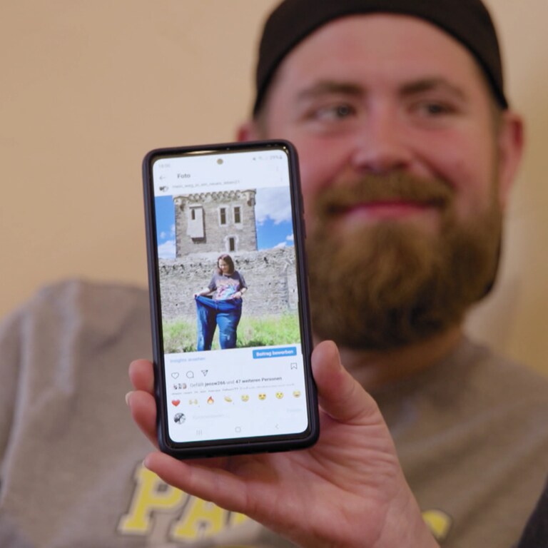 Instagram-Seite auf Handy. Ein Mann sitzt im Hintergrund (Foto: SWR)