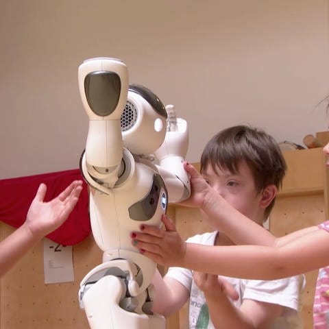 Kinder spielen mit einem Roboter (Foto: SWR)