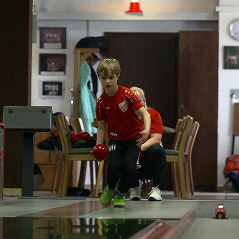 Junge mit einer Bowlingskugel steht an der Bahn (Foto: SWR)