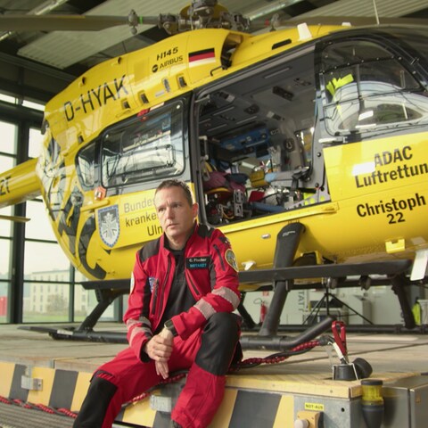 Notarzt sitzt neben Rettungshelikopter (Foto: SWR)