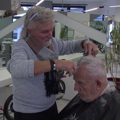 Friseur Eric Schraepel schneidet einem Kunden die Haare (Foto: SWR)