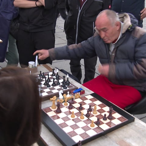 Alter Mann spielt mit Passanten Schach in der Stuttgarter Fußgängerzone