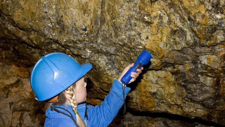 Kind entdeckt mit Taschenlampe Mineralien an den Wänden eines Bergwerkes (Foto: picture-alliance / Reportdienste, picture-alliance / dpa - F. Hecker)