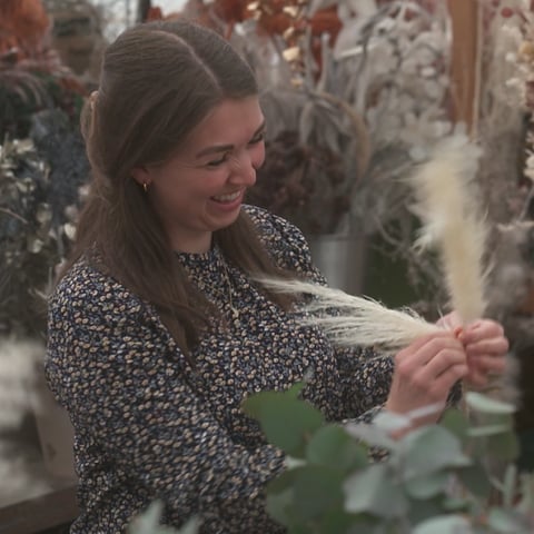 Frau arbeitet mit Trockenblumen