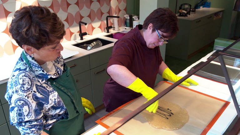 Sonja Faber-Schrecklein und Bettina Buchtal bereiten die Zuckermasse für die Bonbons vor.  (Foto: SWR)