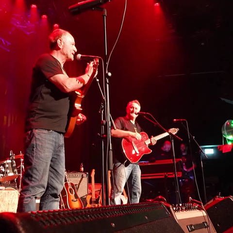 Zwei Personen mit Gitarre auf der Bühne