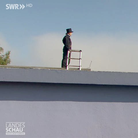 Schornsteinfegerin auf einem Dach
