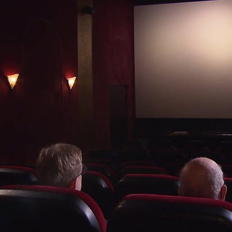 Drei Menschen sitzen in einem Kino