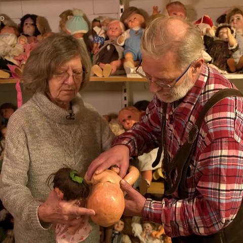 Anita Lüdtke und Bernd Ruffert begutachten eine Puppe