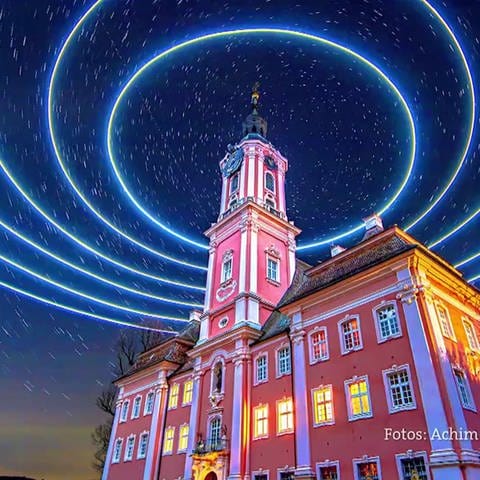 Foto einer Langzeitbelichtung mit Lichtkreisen um einen Turm