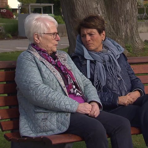 Sonja Faber-Schrecklein sitzt mit einer Frau auf einer Bank