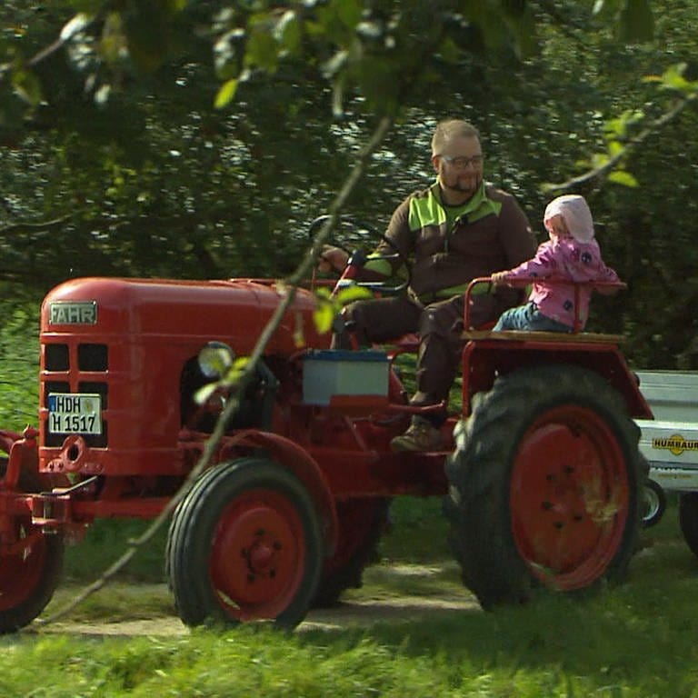 Man fährt mit Kindern auf dem Traktor durch Streuobstwiesen (Foto: SWR)
