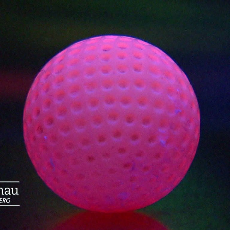 Rosaner Minigolfball im Schwarzlicht