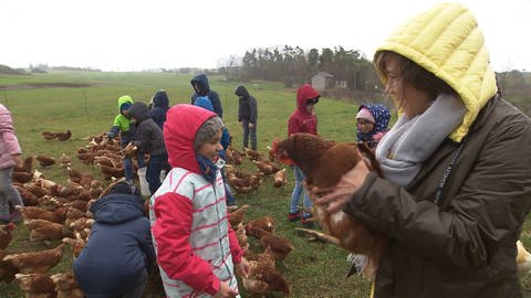 Annette Krause hält ein Huhn auf dem Arm (Foto: SWR)