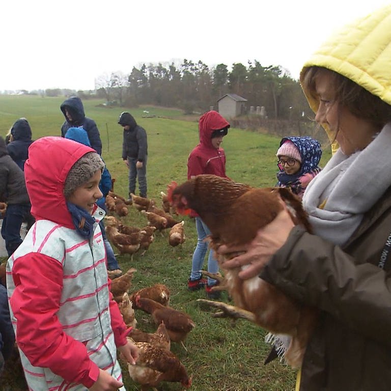 Annette Krause hält ein Huhn auf dem Arm (Foto: SWR)
