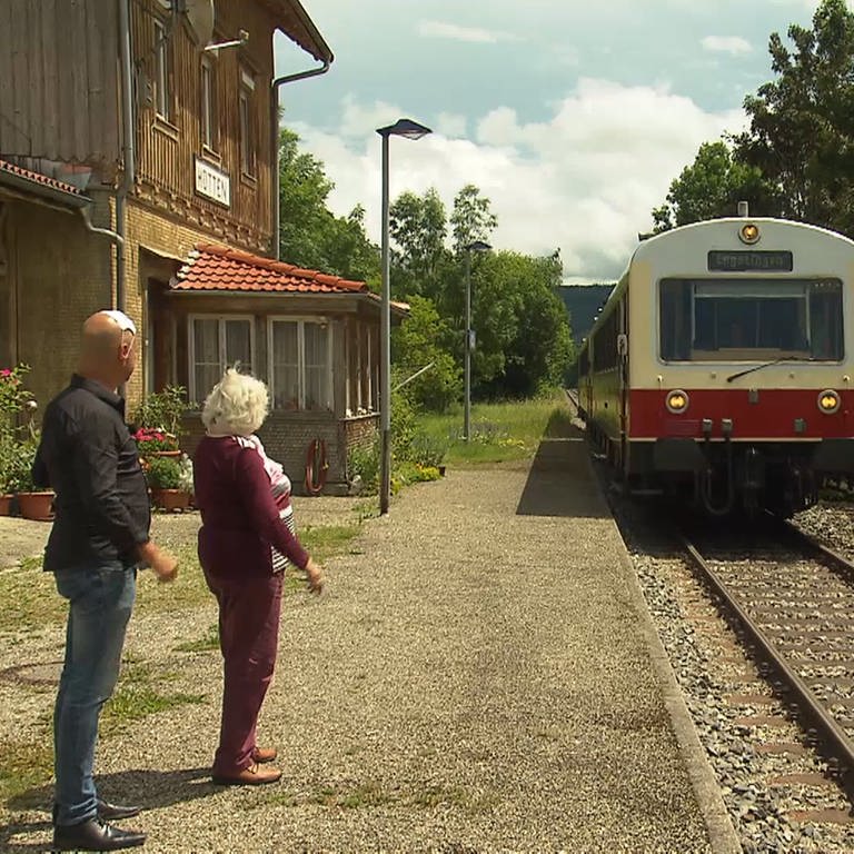 Axel Gagstätter winkt mit Frau einem Zug der Alb-Bahn zu (Foto: SWR)