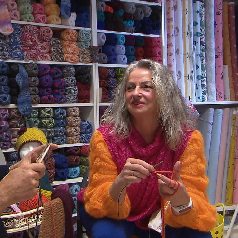 Eine Frau und Axel Gagstätter sitzen beim Stricken in einem Wolle-Laden in Hermaringen