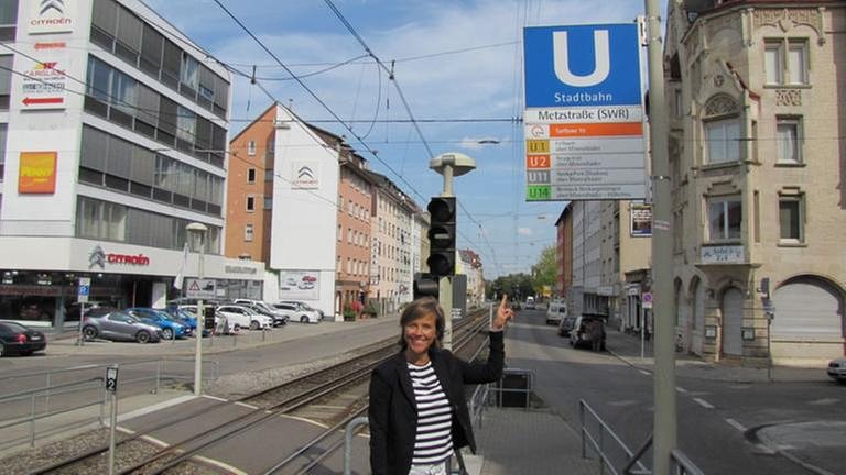 Moderatorin Annette Krause zeigt auf U-Bahn-Schild