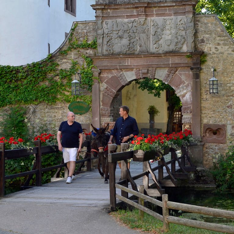 Jens Hübschen (r.) und Frank Brunswig (l.) auf ihrer Landgenuss-Tour in der Eifel auf Burg Rittersdorf. (Foto: SWR)