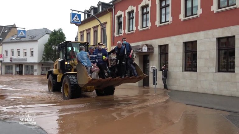 Acht Personen auf Traktor bei Überflutung