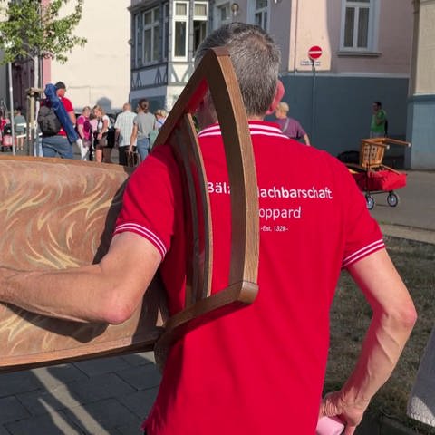 Mann trägt Stuhl (Foto: SWR, SWR)