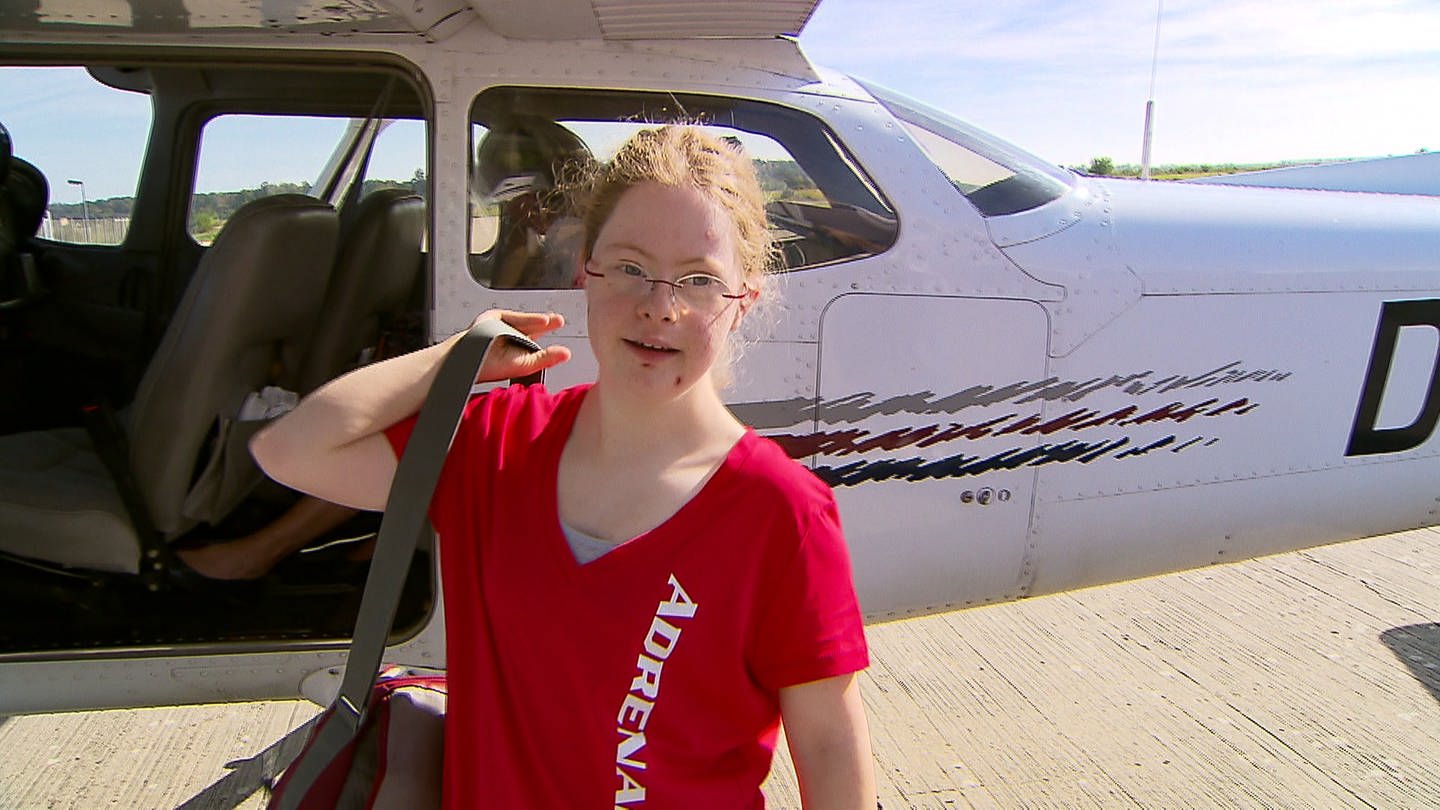 Kind mit Downsyndrom steht vor Flugzeug (Foto: SWR)