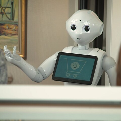 Ein Roboter erklärt etwas vor einem Gemälde (Foto: SWR)