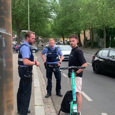 Zwei Polizisten kontrollieren jungen Mann mit E-Scooter (Foto: SWR)
