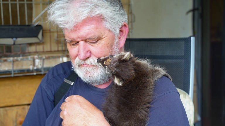 Tierretter Jürgen Völker mit einem Waschbärbaby