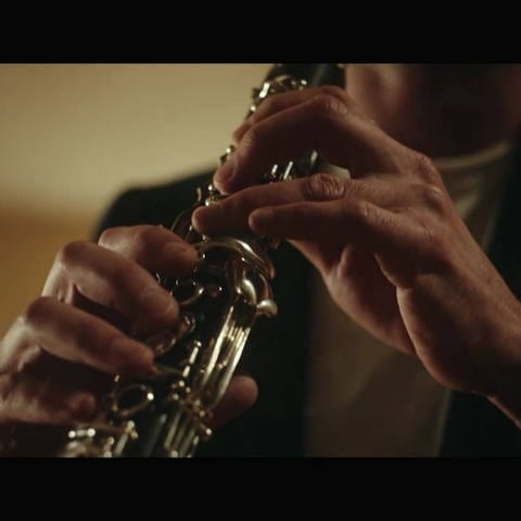 Person spielt Klarinette