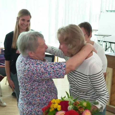Chorleiterin Lilo Musseleck erhält Blumenstrauß als Dank