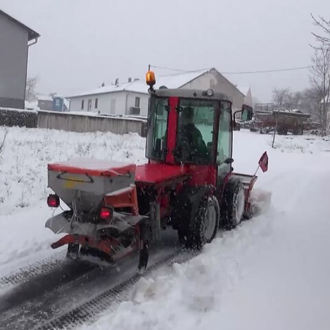 Streufahrzeug auf verschneiter Straße