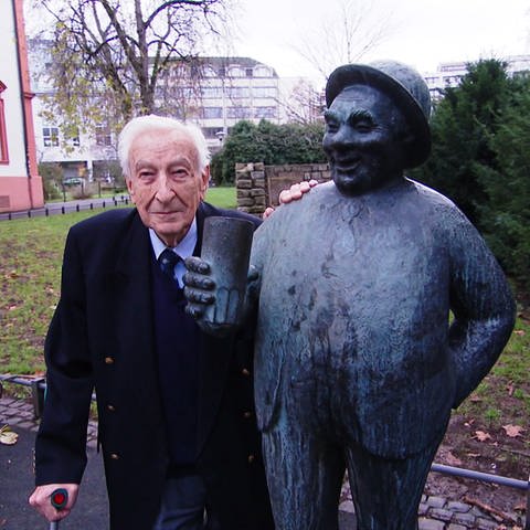 Arthur Schroth mit dem Denkmal seines Großvaters Konrad Schroth, den "Schoppestecher".