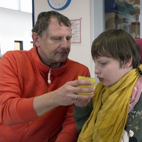 Kai Dietzel hilft seiner Tochter beim Trinken