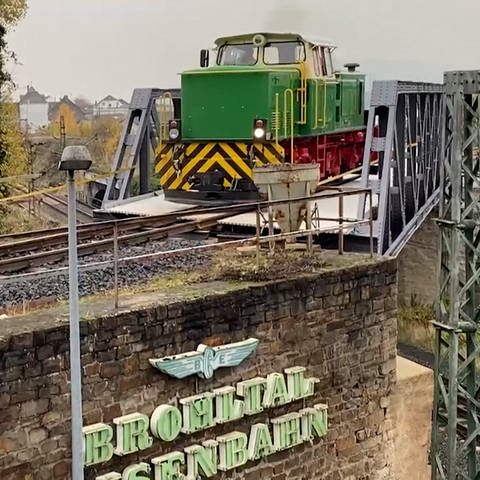 Die dunkelgrüne D4-Lok des Vulkanexpress fährt über eine Brücke der Brohltalstrecke.