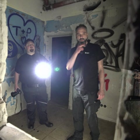 2 Männer besuchen ein verlassenes Munitionslager