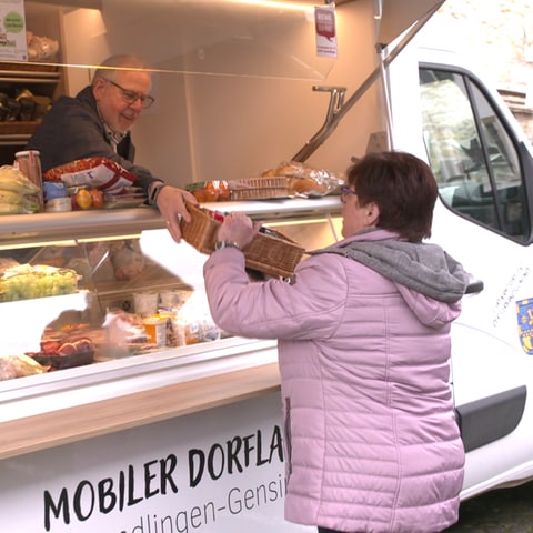 Ein älterer Herr reicht einer Kundin ihren Einkauf über die Auslage und Verkaufstheke eines weißen Renault-Transporters. (Foto: SWR)