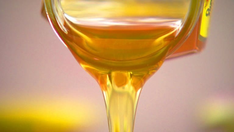 Honig fließt goldgelb, zäh aus einem Glas