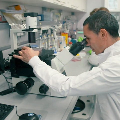 BioTech Gründer Ugur Sahin blickt in ein Mikroskop (Foto: SWR)