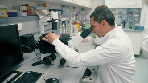 BioTech Gründer Ugur Sahin blickt in ein Mikroskop (Foto: SWR)