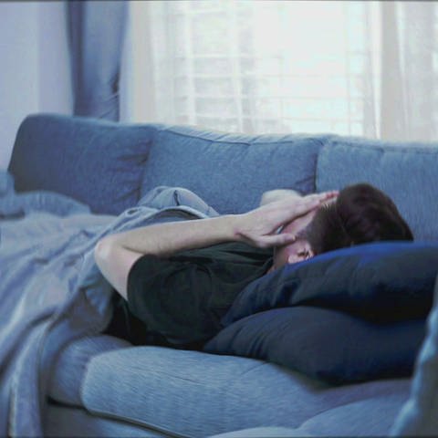 Mann liegt erschöpft auf einem Sofa (Foto: SWR)