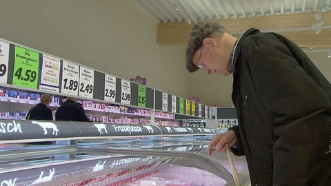 Mann im Supermarkt, sucht in der Kühltheke nach Fleisch-Produkten (Foto: SWR)