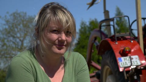 Nachdenkliche Landwirtin vor ihrem Traktor: wie heiß wird 2020? (Foto: SWR)