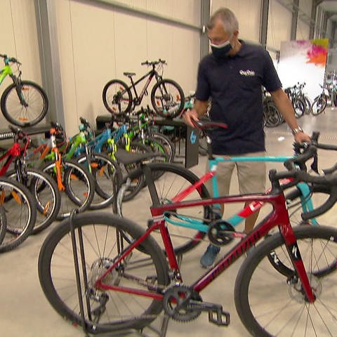Fahrradhändler stellt Rad in einem Verkaufsraum auf (Foto: SWR)