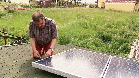 Robert Kuntz steckt sein kleines Solarmodul auf dem Gartenhäuschen ans Stromnetz  (Foto: SWR)