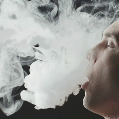 Konsumentvon E-Zigaretten stößt Dampfwolke aus. Ansicht im Profil. (Foto: SWR)