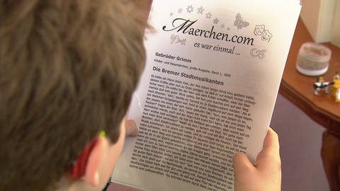 Vorleser liest das Märchen von den Bremer Statdtmusikanten vor. Blick auf das Textblatt. (Foto: SWR)